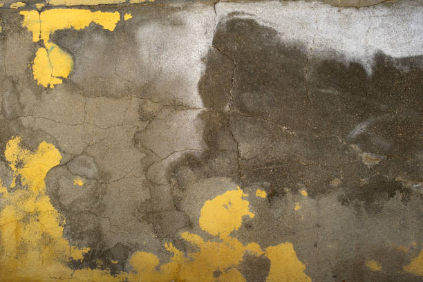 istock Old cracked concrete wall with worn out yellow paint 1948624562