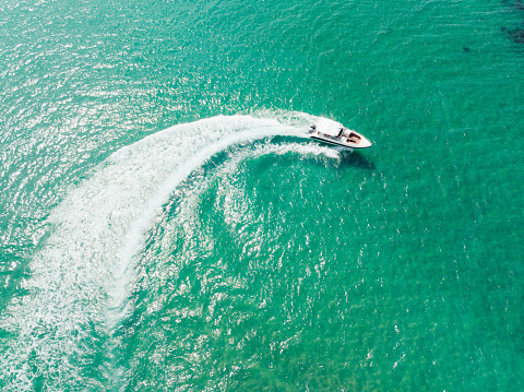 Aerial view of Speed boat at high speed in the aqua sea, Drone view.