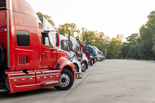 Row of Colorful Semi Trucks Parked at a Rest Area at Dusk