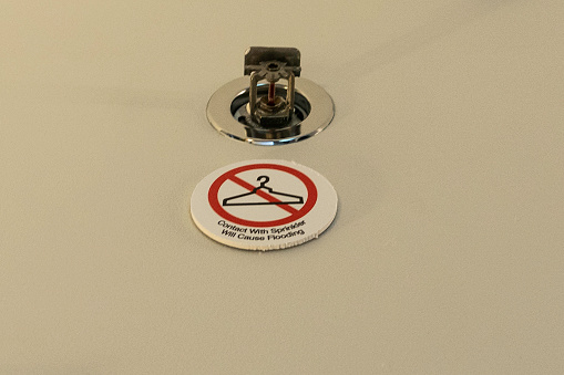 Lafayette, USA - October 15, 2021: A sign on the campus of Purdue warns people not to use the sprinkler system as a coat hanger because the entire building will be doused in water if the metal device is touched.