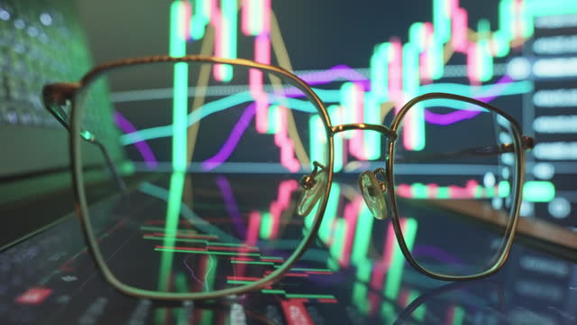 Eyeglasses on Financial trading chart at digital display .
