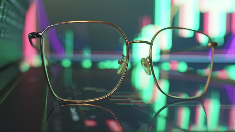 Eyeglasses on Financial trading chart at digital display .