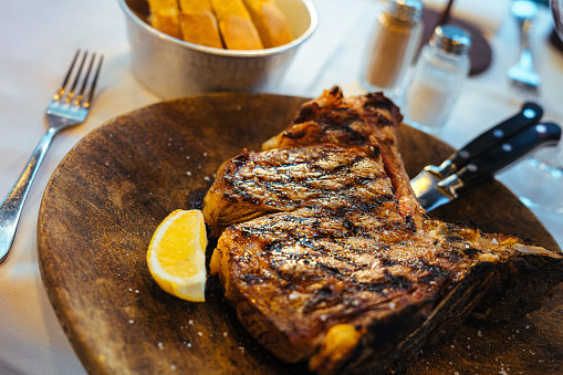 Close-Up Florentine T-Bone Steak and Lemon Wedge in Florence, Italy