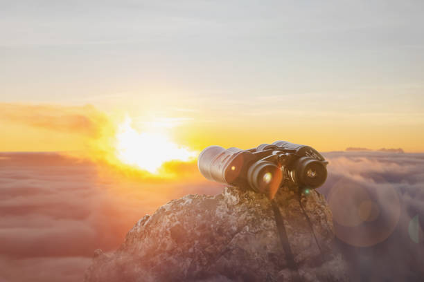 istock binoculars on top of rock mountain mist at beautiful sunset background. 1949051384