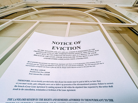 Paper Eviction Notice Taped to the Front Door of a Home in a Residential Suburban Neighborhood