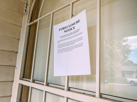 Paper Foreclosure Notice Taped to the Front Door of a Home in a Residential Suburban Neighborhood in the USA