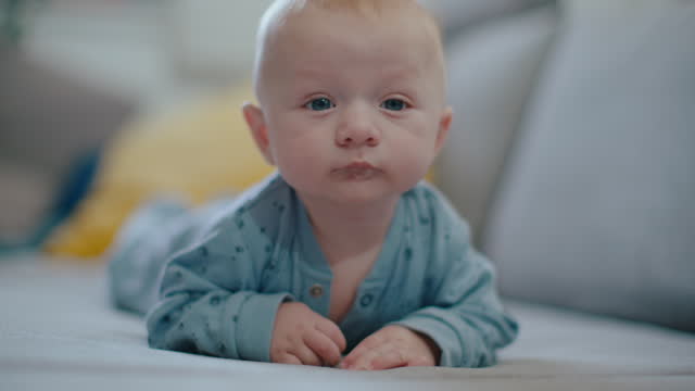 SLO MO Portrait of Cute Baby Boy Enjoying Tummy Time on Sofa at Home