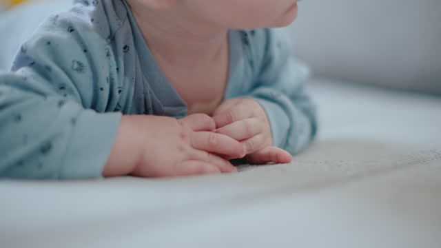 SLO MO Handheld Shot of Cute Baby Boy Sucking Thumb while Lying on Sofa at Home