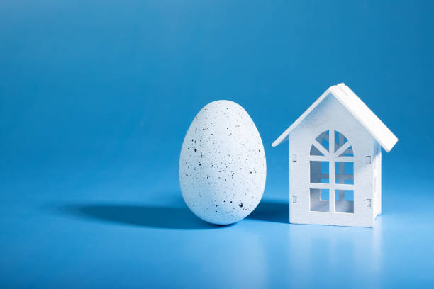 istock spring mortgage, Easter egg and house on blue background, springtime celebration, home decor, festive day 1949177955