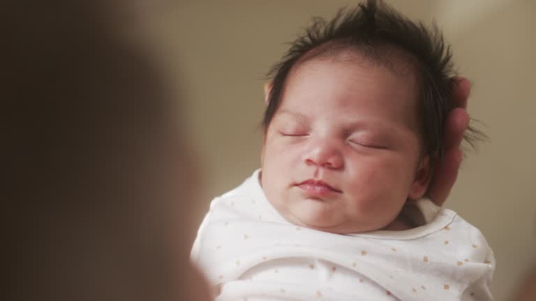 New Born Baby Sleeping Peacefully in the Arms