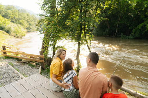 Photo of a family fishing along the riverbank.