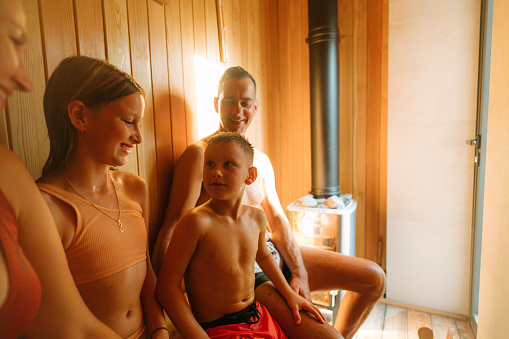 Photo of a  family enjoying a tranquil moment together in the warmth of a sauna.