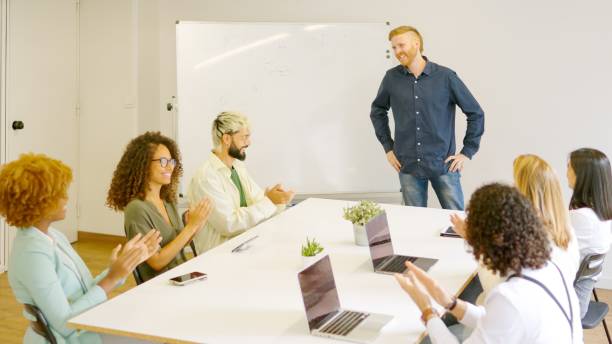 istock Coworkers applauding a man after a presentation in a meeting 1949237744
