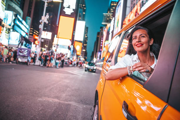 Taxi ride in Times Square, New York City Hispanic adult woman riding a taxi in Manhattan looking out of the car window. taxi stock pictures, royalty-free photos & images