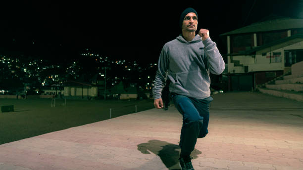 istock Man does squat exercises for his fitness routine outdoors at night. 1949260481