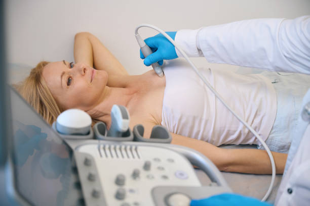 Female getting her breast examined by doctor at modern clinic stock photo