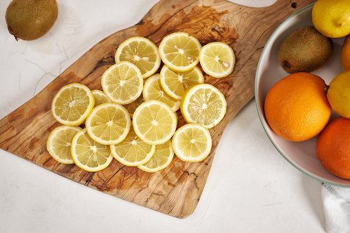 Fresh Sliced organic lemons on wooden cutting board.