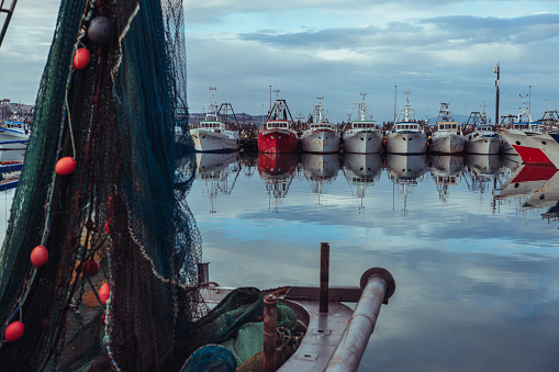 Coverack, Cornwall, UK - July 1, 2021.  The picturesque harbour and village of Coverack in Cornwall with small fishing boats moored on a turquoise ocean.