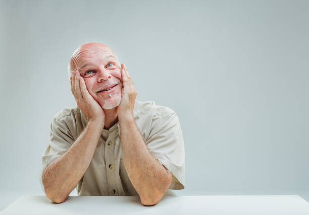 istock Elder's tender daydreaming, hands cupping smiling face 1949290173