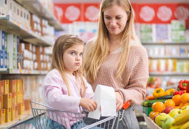 istock Girl with her mother checking an expensive grocery receipt 1949290730