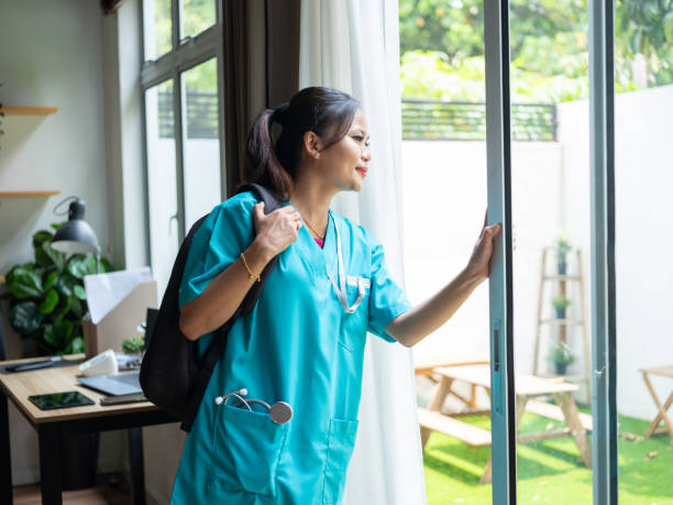 istock Nurse in scrubs looking through the window 1949296694