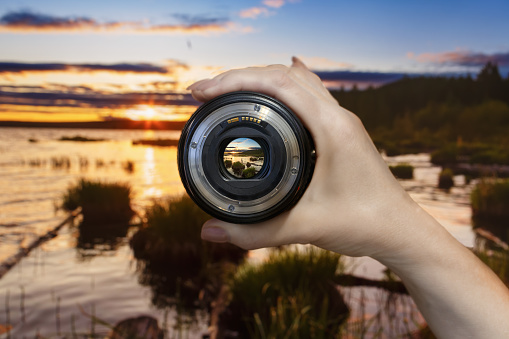 Professional photographer taking picture with modern camera in mountains. Space for text