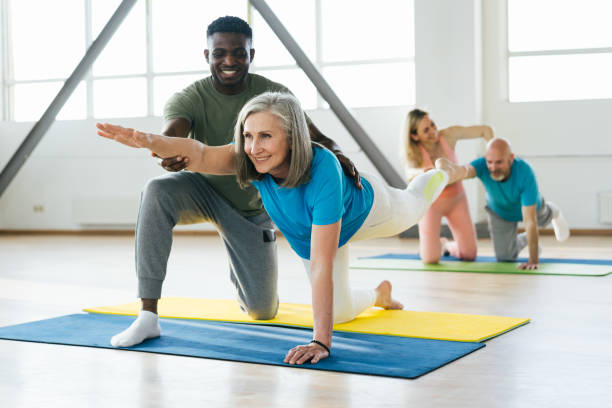 istock African American man helps mature lady athlete with posture 1949326377