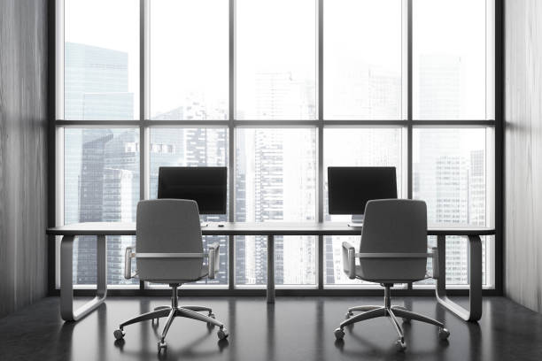 istock Modern coworking interior with pc computers and armchairs near window 1949329672