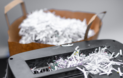 Paper shreds from the shredder, destroyed company documents in the office isolated