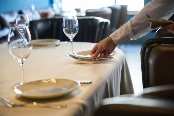 istock Waitress in a restaurant lays out cutlery 1949376786