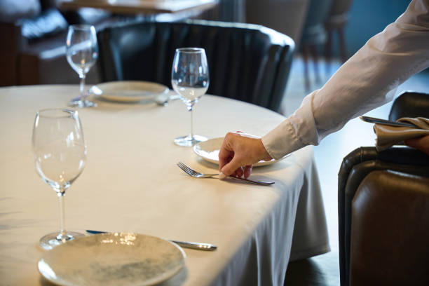 istock Waitress in a cozy restaurant lays out cutlery 1949377302
