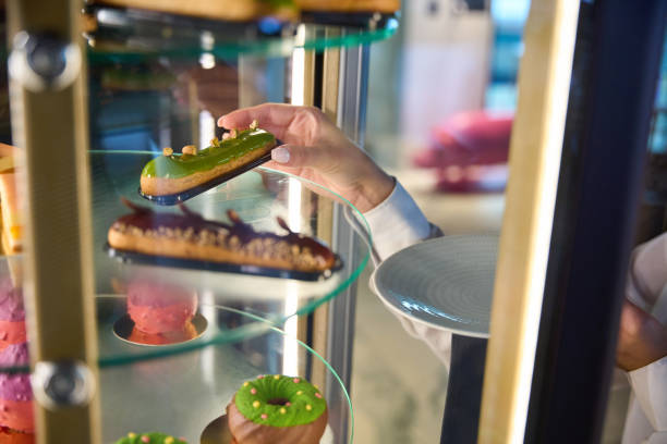istock Waitress takes out an eclair from a transparent display case 1949377841