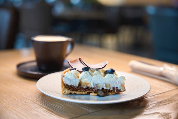 istock Cup of coffee and saucer with cake are on table 1949377861