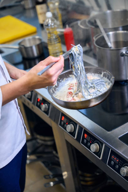istock Chef prepares black spaghetti in a special sauce 1949385168