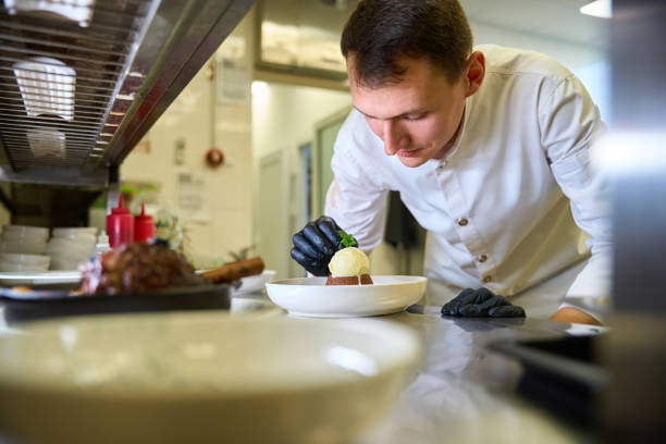 Midsection Of Chef Serving Food In Plate