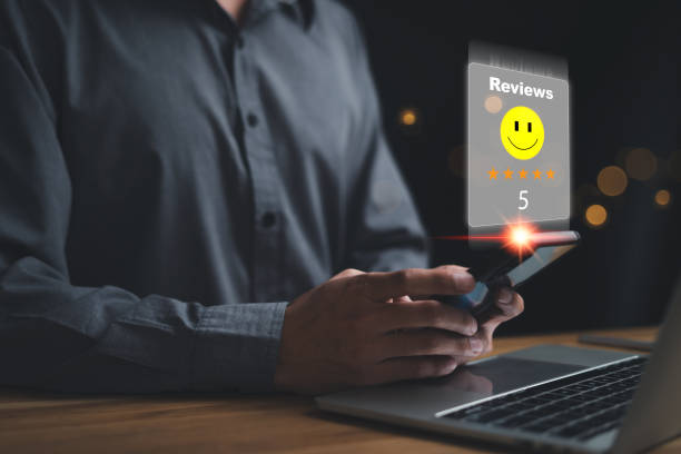 istock Virtual image scenario for evaluating customer satisfaction levels with device system. Ratings stars, reviews, survey responses. happy, information. Man reviews rating 5 on mobile with laptop 1949409605