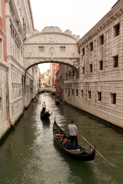 ヴ��ェネツィアのリオ・ディ・パラッツォ運河にあるため息橋の下をくぐるゴンドラ。 - european culture architecture vertical venice italy ストックフォトと画像