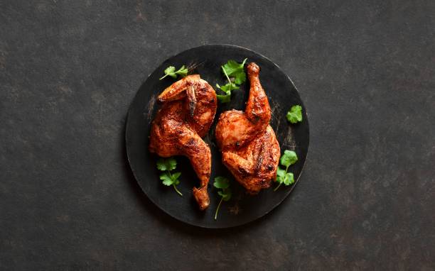istock Roasted half chicken on black wooden board 1949430502