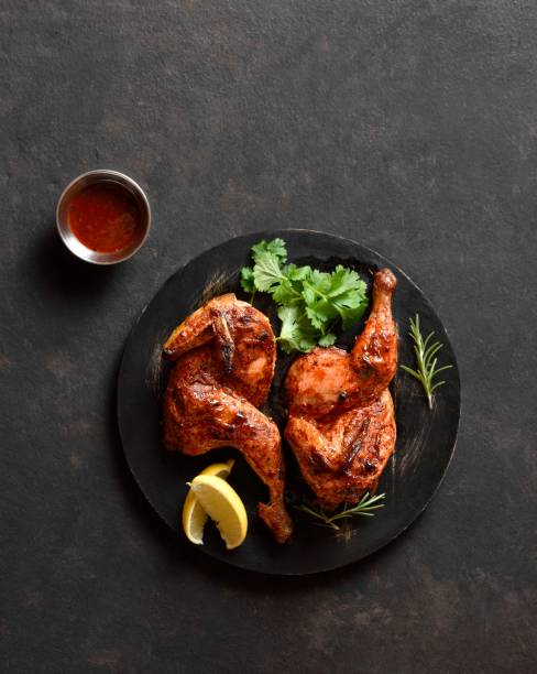 istock Roasted half chicken on black wooden board 1949432077