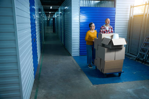 istock Two people carry things in boxes on a cart 1949435857