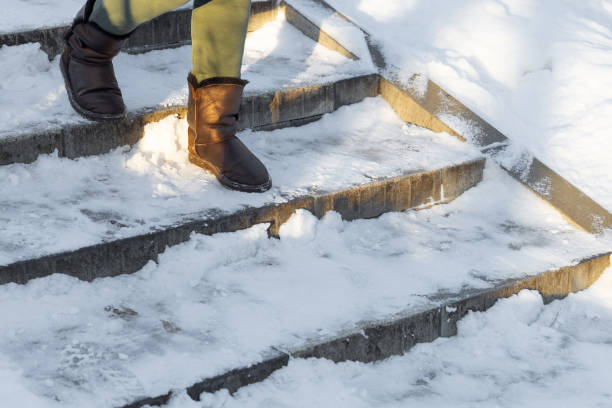 istock a man in winter shoes goes down the snow-covered steps 1949441114