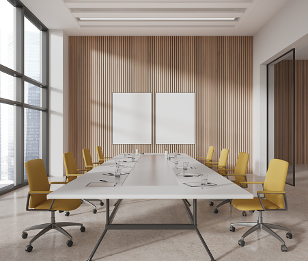 White and wooden office meeting room interior with board, chairs in row on beige concrete floor. Conference workspace with panoramic window on skyscrapers. Two mock up canvas posters. 3D rendering