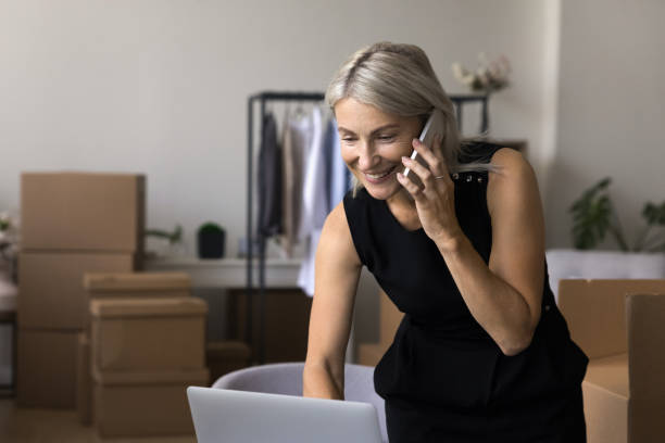 istock Woman talking on smartphone, ordering transportation company, working in warehouse 1949491700
