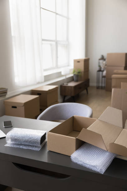 istock Vertical shot office with desk and heap of cardboard boxes 1949500699