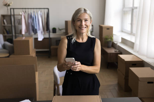 istock Attractive middle-aged woman holds cellphone ordering delivery courier services 1949503499