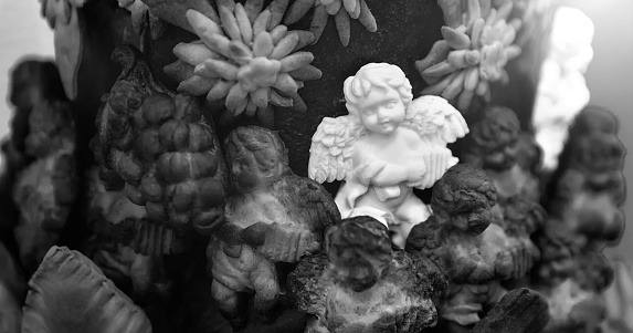 Christmas composition with a figurine of an angel made of sugar on a large pie, surrounded by angels made of dough, close-up. Focus on the foreground.