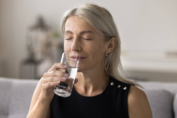 istock Close up peaceful middle-aged woman drinking natural water 1949543492