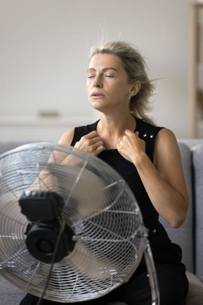 istock Vertical shot mature attractive woman suffers from unbearable hot temperature 1949553003
