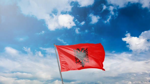 istock flag of albania on blue sky background 1949560048