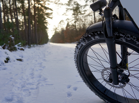 Large Thick Front Wheel of a Fat Bike on a Snow-Covered Path, Cycling Tour Germany